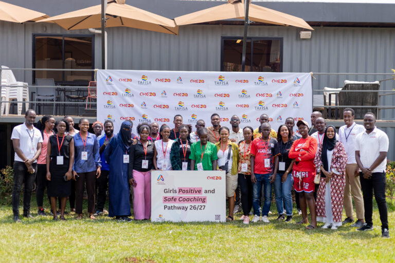 Participants in Cheza’s Girls Positive and Safe Coaching Pathway 26/27 training pose in front of Cheza and TAFISA branding.